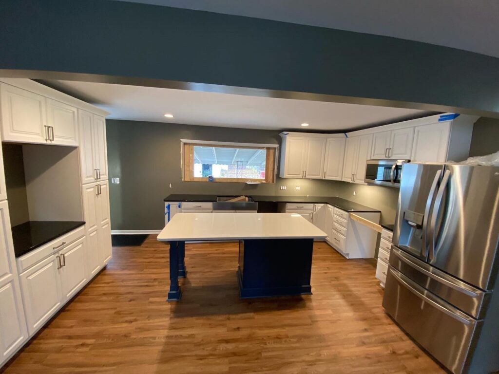 A remodeled open-concept kitchen in Indianapolis featuring a large island, hardwood floors, and bright recessed lighting.