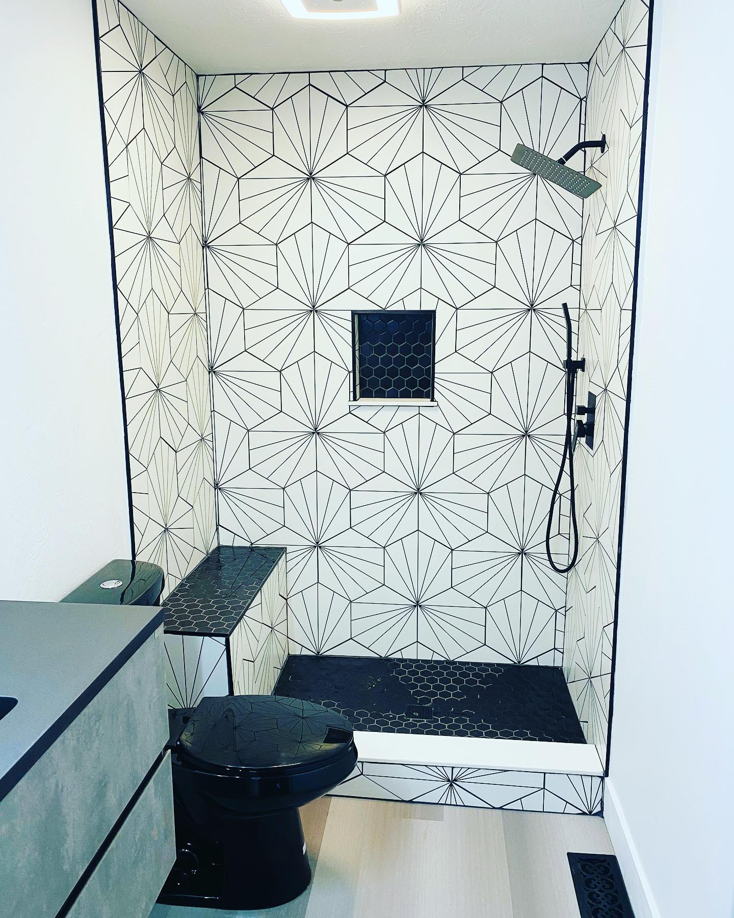 Unique bathroom renovation with modern hex tile and black fixtures by Insta Pro Construction in Indianapolis